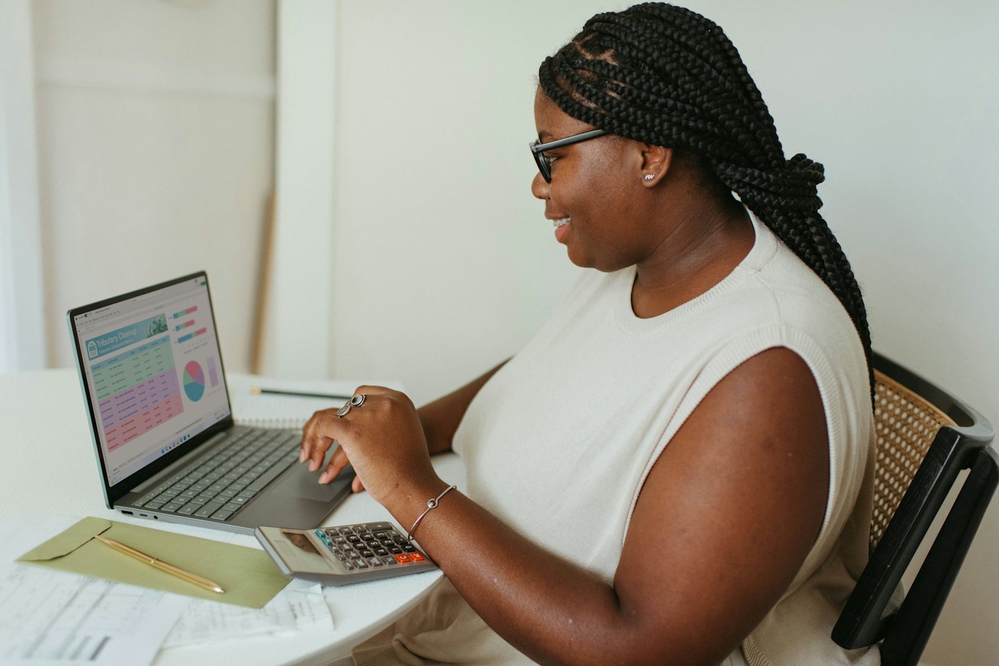 Woman smiling while analyzing data on a laptop.